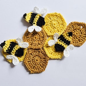 Può includere: Favi di miele all'uncinetto in giallo e oro con tre api all'uncinetto con strisce nere e gialle e ali bianche.