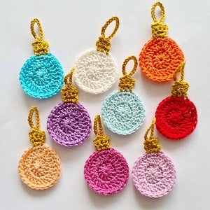 Può includere: Nove ornamenti all'uncinetto in vari colori, tra cui rosso, arancione, giallo, verde, blu, viola e rosa. Ogni ornamento ha un anello dorato per appenderlo.