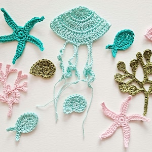 May include: A set of crocheted sea-themed ornaments in various colours, including a jellyfish, starfish, seaweed, and seashells.