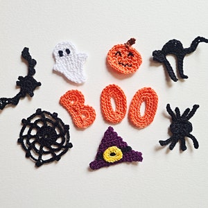 May include: A set of crocheted Halloween decorations, including a ghost, a pumpkin, a spider, a witch's hat, and the word "BOO" in orange yarn.