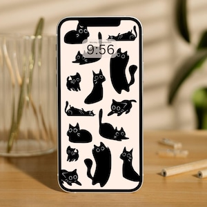 May include: A smartphone displays a wallpaper featuring a pattern of black cat silhouettes on a cream background. The time, 9:56, and the date, Monday 22 September, are visible at the top. The phone is on a wooden surface.