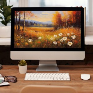 May include: A desktop computer displays a vibrant landscape painting of a field of wildflowers and trees in autumn colors. The computer sits on a wooden desk with a keyboard, mouse, and a yellow mug.