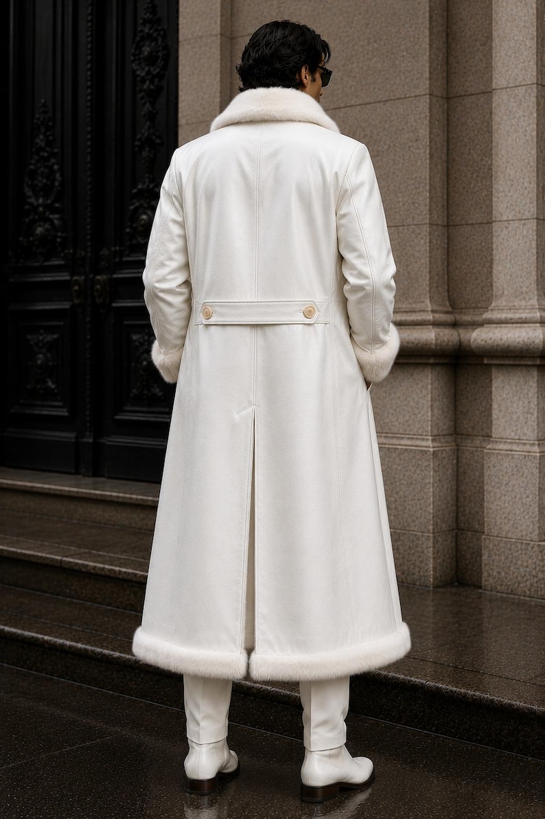 Puede incluir: Un abrigo largo blanco con cuello y pu&ntilde;os de piel. El abrigo presenta un cintur&oacute;n abotonado en la cintura y una abertura en la espalda. La persona lleva pantalones y botas blancas. Dise&ntilde;o cl&aacute;sico y elegante.