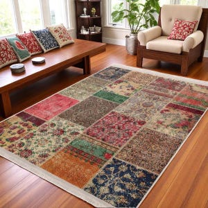 May include: A multi-colored patchwork rug with a cream background and a white border. The rug is made up of various squares of different colors and patterns, including red, green, blue, and brown. The rug is laid out on a wooden floor in a living room setting.