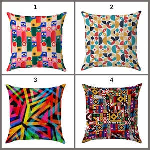 Könnte beinhalten: Vier quadratische Kissen mit farbenfrohen geometrischen Mustern. Die Kissen zeigen Designs mit Augen, Sternen und Rechtecken in leuchtenden Farben wie Rot, Rosa, Grün und Gelb. Die Kissen sind quadratisch und aus Stoff.