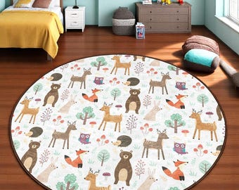 Könnte beinhalten: Ein runder, weißer Spielteppich mit braunem Rand. Der Teppich zeigt ein sich wiederholendes Muster von Waldtieren, darunter Hirsche, Füchse, Bären, Eulen und Kaninchen. Die Tiere sind von Bäumen, Pilzen und anderen Waldelementen umgeben.