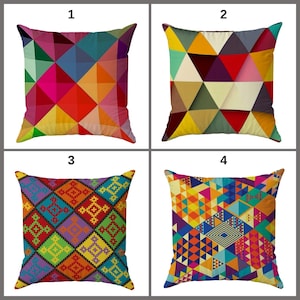 Op de afbeelding: Vier vierkante kussens met geometrische ontwerpen. De kussens hebben kleurrijke patronen van driehoeken en andere vormen in verschillende kleuren, waaronder rood, geel, blauw en groen. Elk kussen heeft een uniek ontwerp.