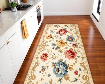 May include: A rectangular floral rug with a cream background and a border of gold scrollwork. The rug features large, colorful flowers in shades of red, blue, and yellow, creating a vibrant and decorative accent for a kitchen or hallway.