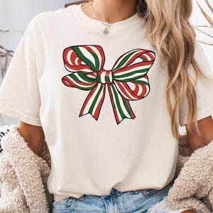 Camiseta navideña, camiseta navideña con lazo, camiseta navideña de moda, camiseta festiva, Navidad, Comfort Colors®