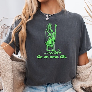 May include: Dark gray t-shirt with a neon green graphic of a robed figure holding a staff, with the text "Go on now. Git." The shirt is made of a soft material.