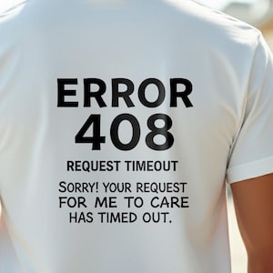 Può includere: T-shirt bianca con la scritta "ERROR 408 REQUEST TIMEOUT SORRY! YOUR REQUEST FOR ME TO CARE HAS TIMED OUT" in nero. La maglietta è indossata da una persona, con la schiena della maglietta rivolta verso la fotocamera.