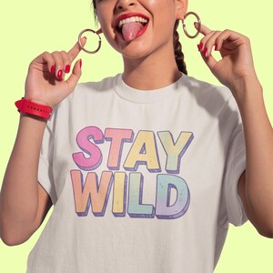 Camiseta "Stay Wild", estilo retro de los 80 con letras desgastadas en tonos pastel, ideal para el verano, un regalo ideal.