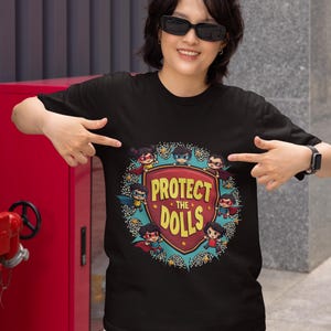 Protect The Dolls shirt, comic-style superhero dolls graphic tee, women's safety and empowerment shirt, feminist gift idea