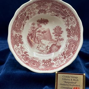 Può includere: Ciotola vintage bianca e bordeaux con bordo smerlato. La ciotola presenta una scena paesaggistica dettagliata e motivi floreali. Il testo sull'etichetta recita "Ciotala Vintage Villeroy & Boch 'Burgenland' - Mettlacher Kupferdruck - Unterglasur 681."