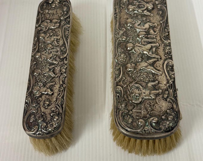 Antique embossed dress brushes.