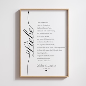 Puede incluir: Una impresión enmarcada con un marco de color madera clara. La impresión presenta la palabra "Liebe" en una elegante escritura en el lado izquierdo, con un poema en texto negro sobre un fondo blanco. La parte inferior de la impresión incluye nombres y una fecha.