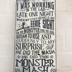 May include: A rectangular wooden sign with the text "I WAS WORKING IN THE LAB LATE ONE NIGHT WHEN MY EYES BEHELD AN EERIE SIGHT" in black lettering. The sign has a distressed, vintage look, with a white background and black accents.