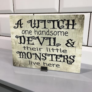 Rustykalna prymitywna wiedźma przystojny diabeł małe potwory mieszkają tutaj tabliczka z napisem Halloween zniszczony szykowny vintage znak