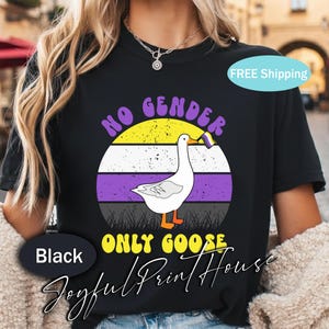 May include: Black t-shirt featuring a white goose holding a non-binary pride flag. The design includes the text "NO GENDER ONLY GOOSE" in a retro style. The shirt is from Joyful Print House.