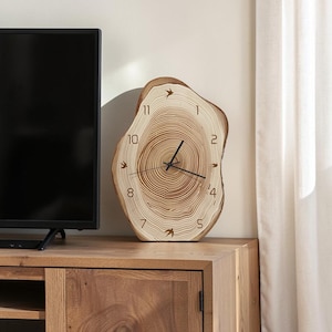 May include: A wall clock crafted from a natural wood slice featuring visible tree rings, black clock hands, and black numerals from one to eleven. Small black bird silhouettes are positioned at the twelve, three, six, and nine o'clock positions.