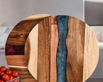May include: Two round wooden serving boards with a decorative resin inlay. One board has a blue resin inlay and the other has a purple resin inlay.