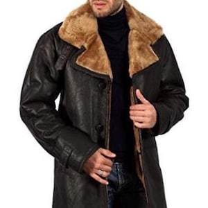 May include: A brown leather coat with a shearling collar and a button fastening. The coat has a belt at the waist and a long length.