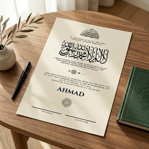May include: A cream-colored Islamic conversion certificate with Arabic calligraphy and English text. The certificate includes the name "AHMAD" and is accompanied by a green book and a black pen on a wooden surface.