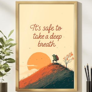May include: Framed art print featuring a whimsical illustration of a frog with a backpack on a hill, with a setting sun in the background. The text "It's safe to take a deep breath" is written in a cursive font.