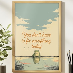 May include: Framed art print featuring a serene frog scene with the text "You don't have to fix everything today." The artwork has a light brown wooden frame, a frog, water, and a sky with clouds.