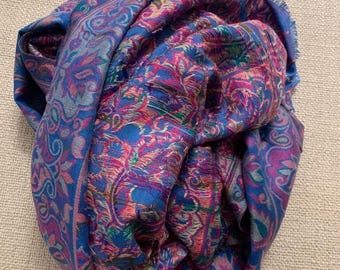 May include: A blue and pink paisley patterned scarf with a fringed edge.
