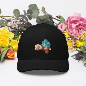 May include: Black trucker hat with a blue and orange anime character embroidered on the front. The character is in a fighting pose with a blue aura.