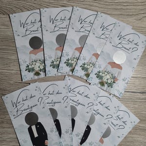 Könnte beinhalten: Eine Sammlung rechteckiger Hochzeitsspielkarten mit Illustrationen einer Braut mit Blumenstrauß und eines Bräutigams im Smoking. Jede Karte hat eine kreisförmige silberne Rubbelfläche und den Text Wer hat die Braut oder Wer hat den Bräutigam.