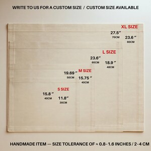 May include: Four stacked rectangular off-white fabric mats in sizes S, M, L, and XL. Text indicates sizes from 15.8 by 11.8 inches to 27.5 by 23.6 inches. Text reads: WRITE TO US FOR A CUSTOM SIZE / CUSTOM SIZE AVAILABLE and HANDMADE ITEM &mdash; SIZE TOLERANCE OF &asymp; 0.8-1.6 INCHES.