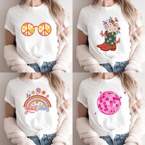 May include: A set of four white t-shirts featuring distinct graphic prints: orange peace sign glasses with floral patterns, a cowboy boot filled with flowers and butterflies, a rainbow with the text good vibes, and a pink disco ball.