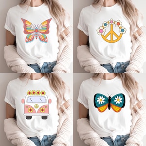 May include: A collection of four white t-shirts featuring graphic prints. The designs include a multi-colored butterfly, a yellow peace sign surrounded by flowers, a pink and white van with floral accents, and a teal butterfly with white daisies.