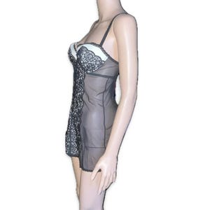 May include: Black and white lingerie set. The set features a sheer black fabric with a white bust and black lace detailing. The straps are black and the garment is designed to be worn as a nightgown or undergarment.