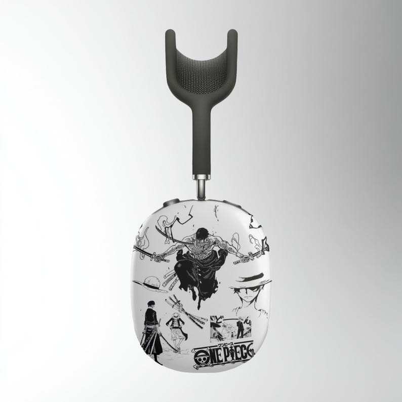 May include: White wireless headphones with a black headband and a black and white graphic design featuring characters from the anime series One Piece. The graphic includes the text "ONE PIECE".