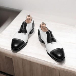 Scarpe Oxford stringate in pelle bicolore bianca e nera, realizzate a mano: modello brogue da uomo con punta rinforzata, ideale per matrimoni.