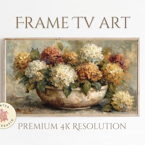 Op de afbeelding: Een ingelijst bloemstilleven. Het kunstwerk toont een kom vol hortensia's in wit, oranje en geel. De tekst "FRAME TV ART" en "PREMIUM 4K RESOLUTION" worden weergegeven.
