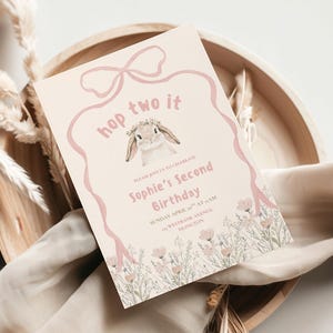 May include: A light pink birthday invitation featuring a bunny illustration and the text "hop two it". The invitation reads "Sophie's Second Birthday" with event details, set against a floral border.