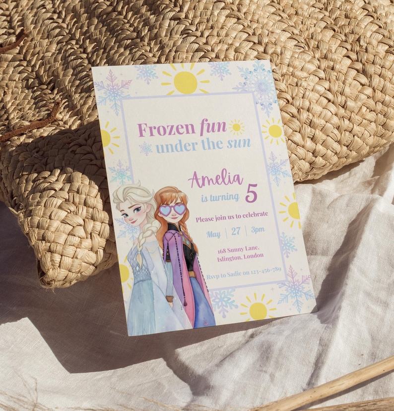 May include: A rectangular birthday invitation card featuring illustrations of two characters with blonde and auburn hair. The text reads Frozen fun under the sun, Amelia is turning 5, Please join us to celebrate, May 27 3pm, 168 Sunny Lane, Islington, London, Rsvp to Sadie on 123-456-789, decorated with yellow suns and blue snowflakes.
