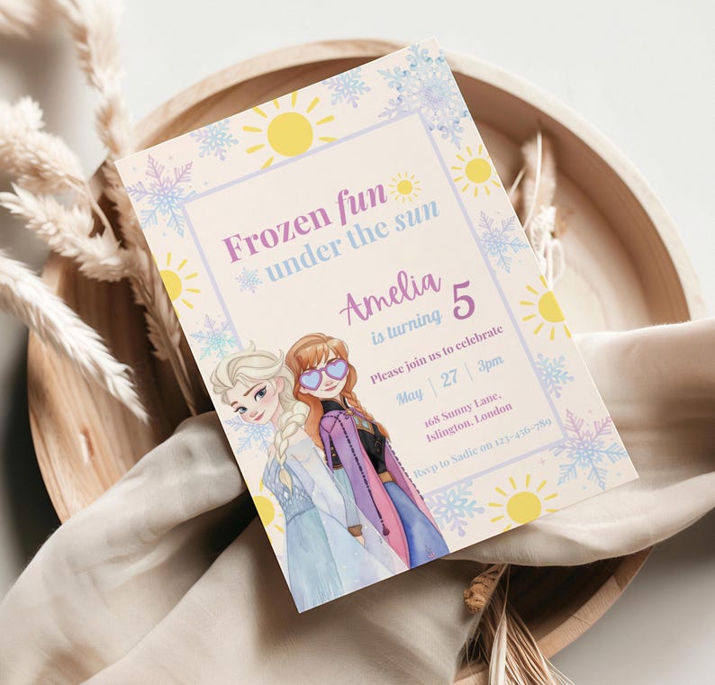 May include: A rectangular party invitation card featuring two animated characters with blonde and auburn hair, wearing blue and purple outfits. The text reads Frozen fun under the sun, Amelia is turning 5, May 27, 3pm, 168 Sunny Lane, Islington, London.