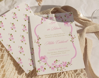 May include: Bridal shower invitation with a floral design. The invitation features the text "Love in Bloom" and details for Millie Caldwell's bridal shower. The invitation is decorated with pink flowers and a pink border.