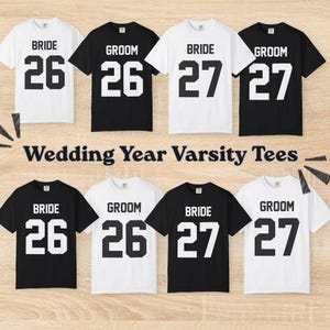 May include: Eight short-sleeve t-shirts in black and white, arranged in two rows. Each shirt features the text BRIDE or GROOM above the numbers 26 or 27 in a varsity-style font. The text Wedding Year Varsity Tees is centered.