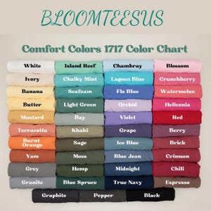 K&ouml;nnte beinhalten: Farbtabelle f&uuml;r Comfort Colors 1717 Bekleidung mit einer gro&szlig;en Auswahl an Farbt&ouml;nen. Die Tabelle zeigt Farben wie Wei&szlig;, Elfenbein, Banane und Senf sowie Farbt&ouml;ne wie Island Reef, Chambray und Blossom. Der Text "BLOOMTEESUS" steht oben.