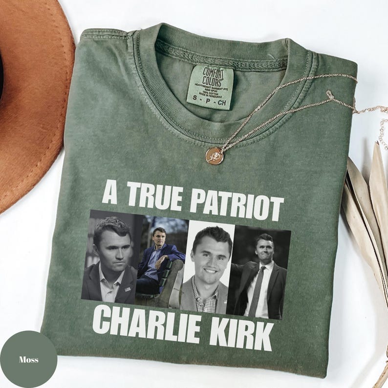 K&ouml;nnte beinhalten: Moosgr&uuml;nes T-Shirt mit dem wei&szlig;en Text "A TRUE PATRIOT CHARLIE KIRK". Das Shirt zeigt eine Grafik von Charlie Kirk in vier verschiedenen Bildern. Eine goldene Halskette und ein brauner Hut sind ebenfalls sichtbar.