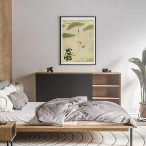 K&ouml;nnte beinhalten: Ein Schlafzimmer-Interieur mit einem Bett, einem Nachttisch aus Holz, einer Lampe, einem B&uuml;cherregal und einem gerahmten Druck einer japanischen Landschaft mit dem Wort "夢" in schwarzer Kalligraphie. Der Druck h&auml;ngt an einer wei&szlig;en Wand.