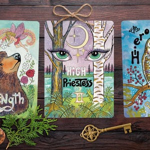 Wild Waters Edge Tarot Oracle of the Mystic Muse. Northwoods brown bear and fairy, mystical eyes of the forest High Priestess, a wise owl as the Hierophant, Tarot spread.