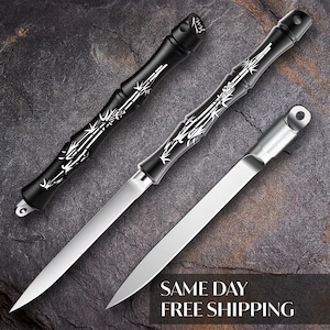 May include: Three letter openers with silver blades. Two have black handles with white bamboo designs, and the third has a silver handle. The handles have a loop at the end for hanging.