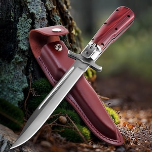 May include: A stainless steel hunting knife with a polished blade and a wooden handle. The knife is displayed with a burgundy leather sheath. The handle has a reddish-brown wood grain pattern. The knife is designed for outdoor use.